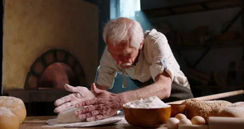 Senior bakery worker putting flour on bread dough and forming a loaf, putting 스톡 동영상 156297843