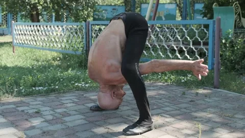 Senior bald man bends stretching out body and talks closeup Stock Footage 201959318