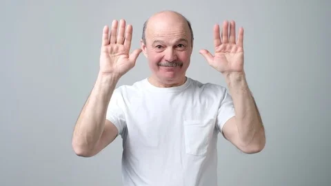 Senior bald man saying bye to his friends waving his hands. Stock Footage 102807668