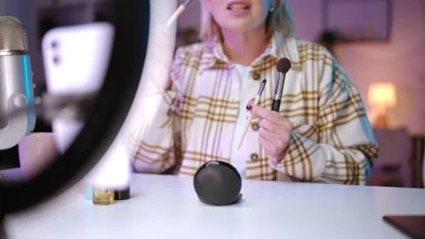 Senior beauty blogger explaining usage of facial brushes, makeup tutorial Stockbeeldmateriaal 200893311