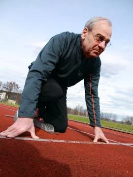 Senior beim Sprintstart Stock Photos
