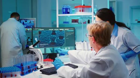 Senior biochemist writing on computer the changes in vaccine Stock Photos