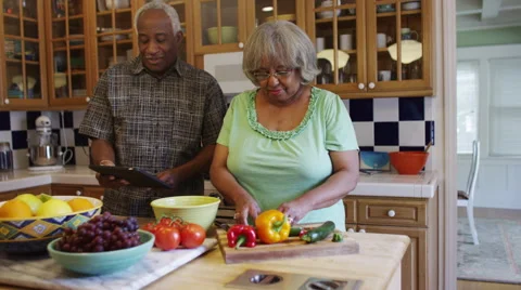 Senior black couple cooking together in kitchen Stock Footage