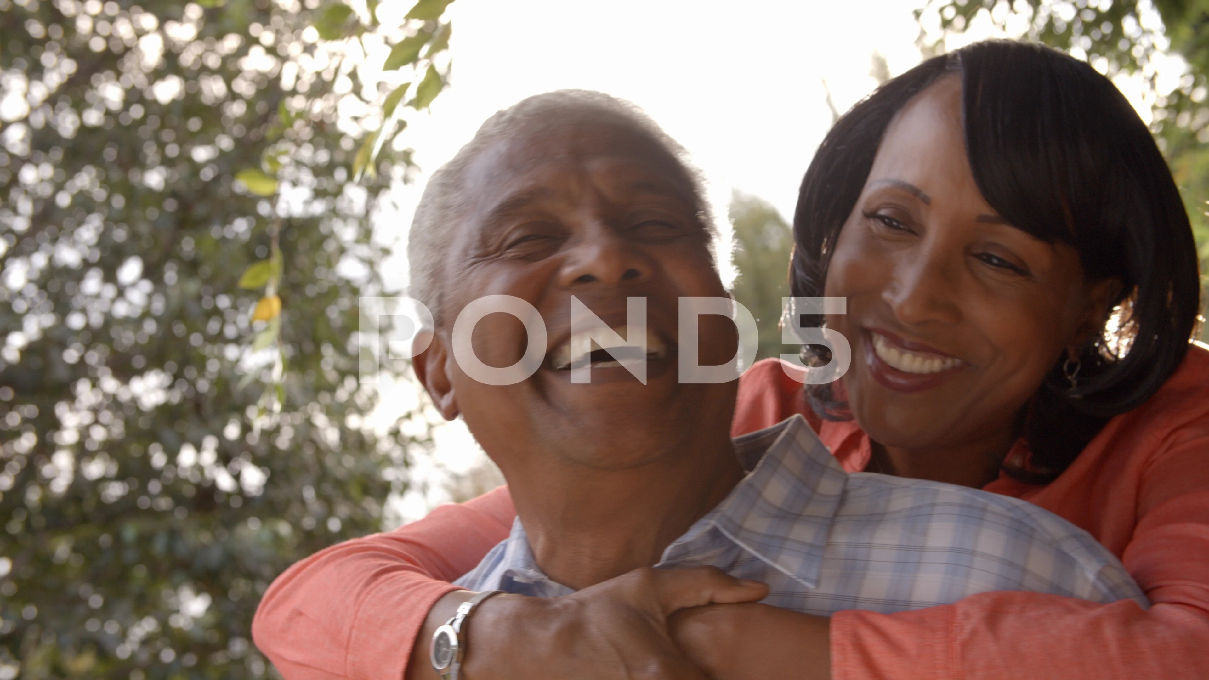 Senior black couple piggyback in garden, close up