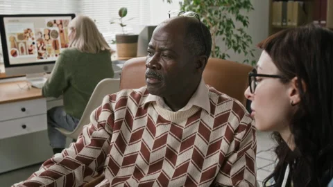 Senior Black Man Receiving Software Training from Younger Colleague in Office Stock Footage 328601920