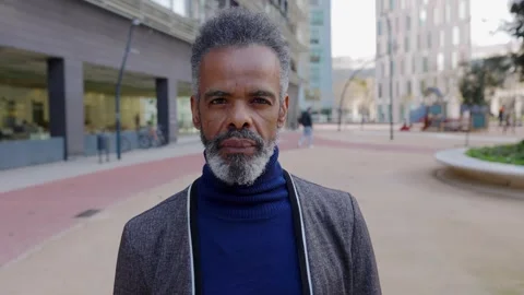 Senior Brazilian man looking at camera standing outside at urban city area. Stock Footage 287914933