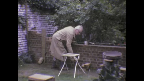 Senior bricklayer building a garden wall in the 1970s uk Stock Footage 310660277