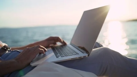 Senior business man using laptop on the beach Stock Footage 80690412