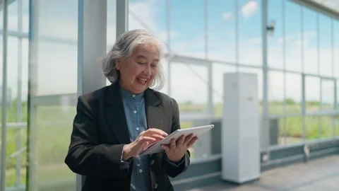 Senior business smiles while using tablet inside greenhouse Stockbeeldmateriaal 344937801