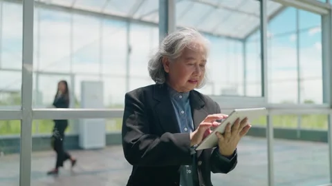Senior business smiles while using tablet inside greenhouse 스톡 동영상 344937814