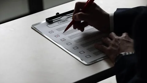 Senior Businessman Completing Checklist With Red Pen at Office Desk Stock Footage 343941564