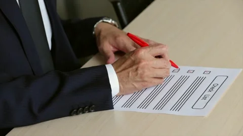 Senior Businessman Completing Checklist With Red Pen at Office Desk 動画素材 343942457