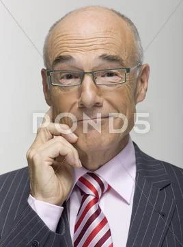 Senior businessman, hand on chin, portrait Stock Photos