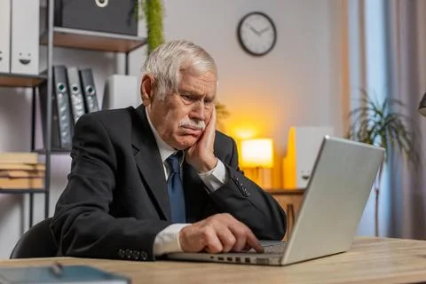 Senior businessman having software problems with laptop seeing error Fotos de archivo