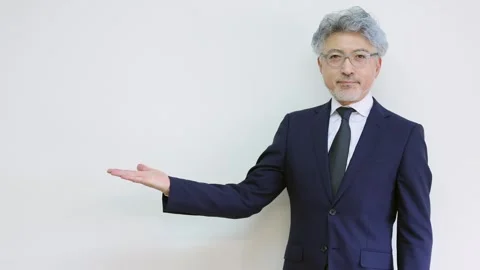 Senior Businessman Presenting Copy Space With Open Palm Gesture Stock-Footage 343932402