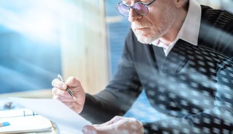 Senior businessman reading a document; light effect Stock-Fotos