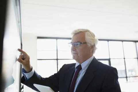 Senior businessman using touch screen television in conference room Stock Photos