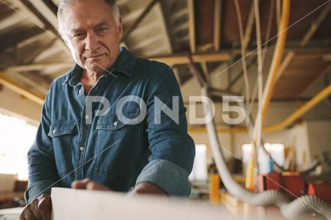 Senior carpenter inspecting the wooden bar Stock Photos