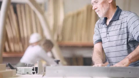 Senior carpenter using a table saw in a woodworking workshop Stock Footage 337882307