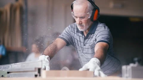 Senior carpenter using table saw for woodworking Stock Footage 337882400