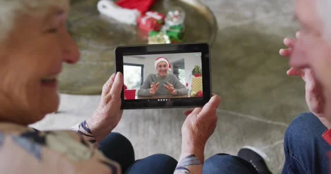 Senior caucasian couple using tablet for christmas video call with happy men on Stock Footage 330786205