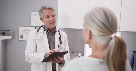 Senior Caucasian doctor using a tablet Video stock 58232380
