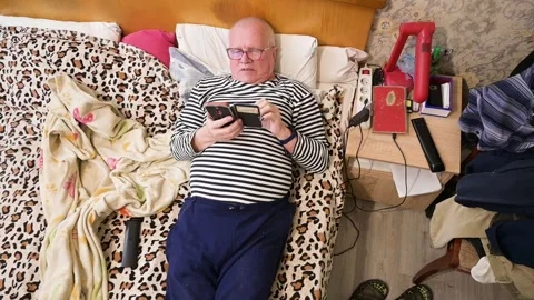Senior Caucasian Man Lying in Bed and Scrolling on His Smartphone at Home Stock Footage 342095848