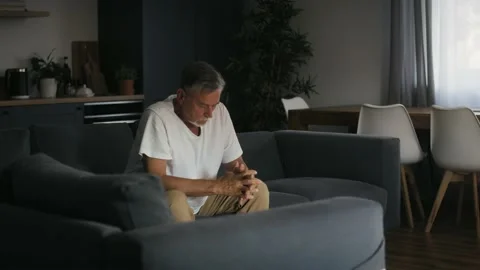 Senior caucasian man with mental problem sitting on couch in home Stock-Footage 218725111