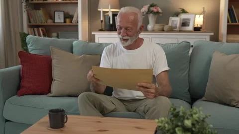 Senior caucasian man open mail letter or document envelope at home Stock Footage 251570513