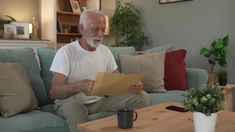 Senior caucasian man open mail letter or document envelope at home Vídeo Stock 251570554
