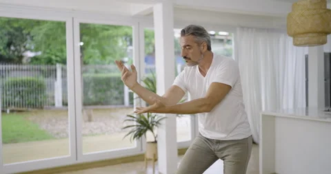 Senior caucasian middle aged man practicing graceful martial arts movements Stock Footage 345478706