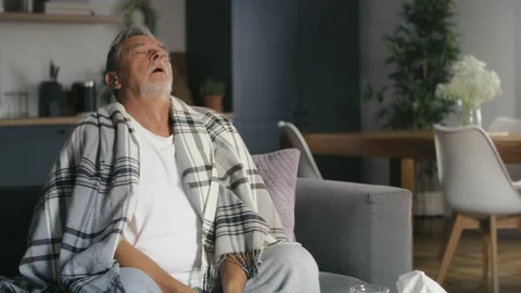 Senior caucasian sitting at the sofa with cold and flu Stock Footage 218719132