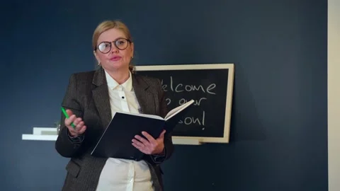 Senior caucasian teacher is explaining the lesson in front of the classroom near Stock Footage 147203097