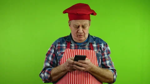 Senior chef with fingers fast texting message chatting on his smartphone. Stock Footage 266079369