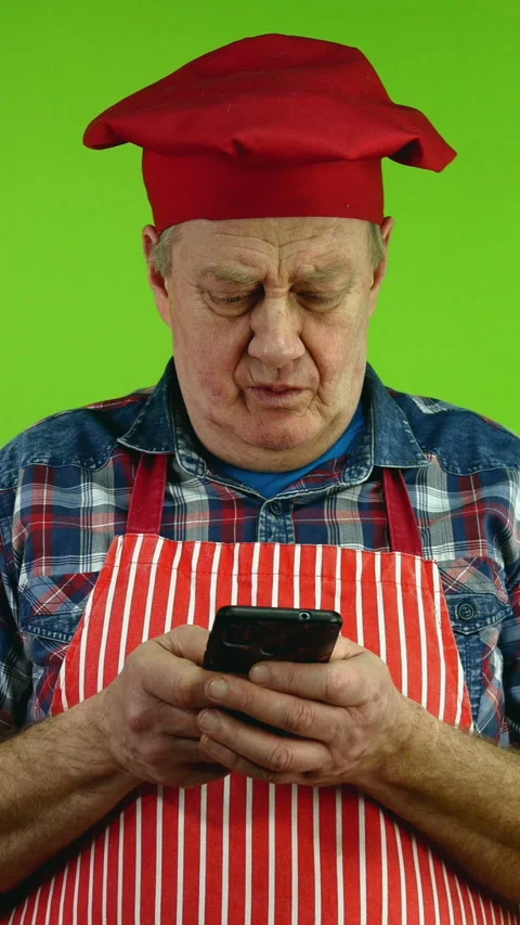 Senior chef with fingers fast texting message chatting on his smartphone. Stock Footage 266148177