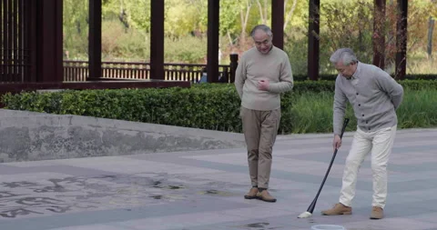 Senior Chinese man practicing calligraphy in the park,4K Stock Footage 227175747