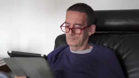 Senior citizen with glasses using a tablet Stock Footage 290954288