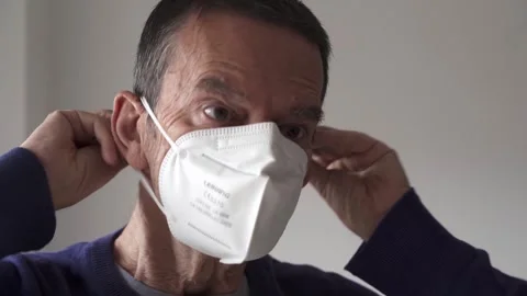 Senior citizen removing a kn95 or ffp2 facemask Stock Footage 290954259