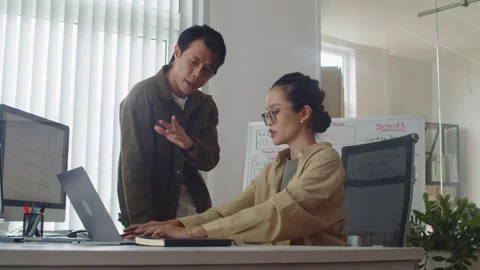 Senior Coder Instructing New Employee Working on Laptop at Modern Office Stock Footage 256977690