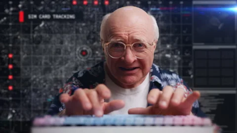 Senior computer geek in glasses tracking sim card location, typing like a hacker 스톡 동영상 307196093