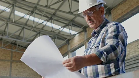 Senior construction manager looking at blueprints at building site. Stock Footage 105223487
