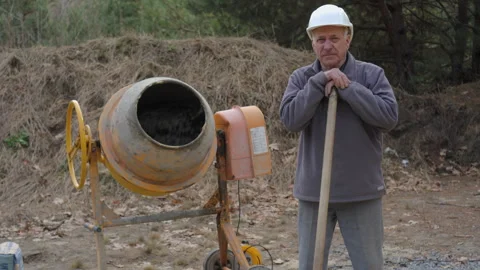 Senior Construction Worker Standing by Concrete Mixer Stock Footage 307857144
