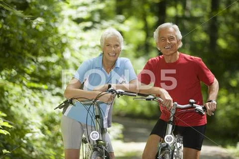 Senior couple with bikes, smiling, portrait Stock Photos