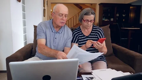 Senior couple calculating bills cost at home Stock Footage