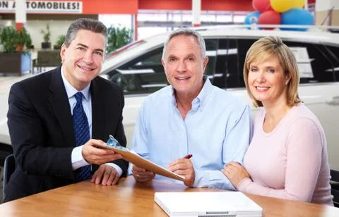 Senior couple with car dealer agent. Stock Photos