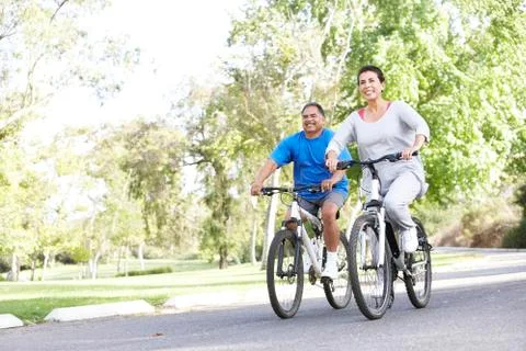 Senior couple cycling in park Stock Photos