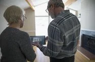 Senior Couple With Digital Tablet Using Augmented Reality To Plan Living Room Re Stock Photos