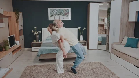Senior couple doing back-to-back yoga exercise at home 動画素材 327463042
