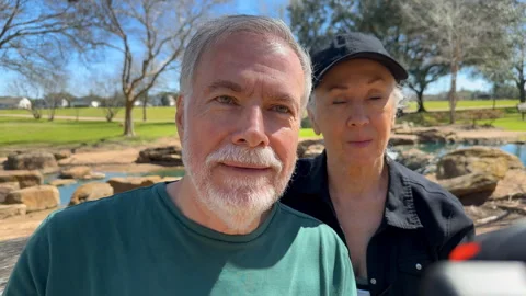 Senior couple doing a facetime with someone using their phone Stock Footage 303172228