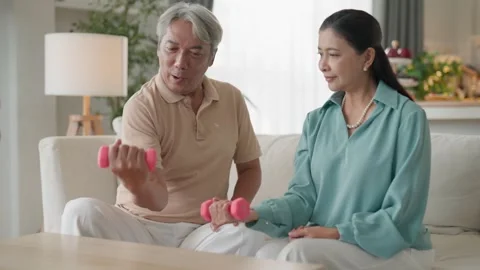 Senior couple dumbbell exercise home living room fitness wellness support s.. Stock Footage 332748670